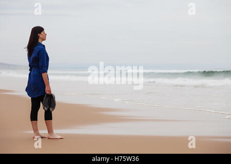 Einsam und depressiv Frau das Meer in einem verlassenen Strand an einem Herbsttag. Stockfoto