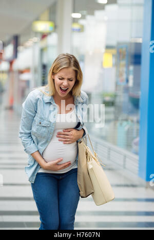 Schwangere Frau berühren ihren Bauch Schmerzen Stockfoto