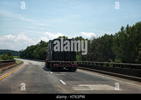 Sattelauflieger bedeckt in schwarzen Falle schleppen Fracht auf der Autobahn Stockfoto
