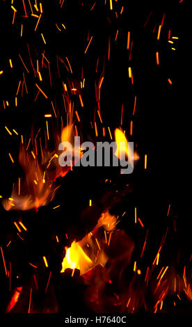 Nahaufnahme des brennenden Lagerfeuer Protokolle mit Flammen und Funken, vor einem dunklen Hintergrund. Stockfoto