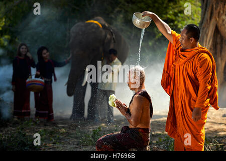 Porträt eines Mönchs gießt Wasser auf eine andere Mönche Kopf, Thailand Stockfoto