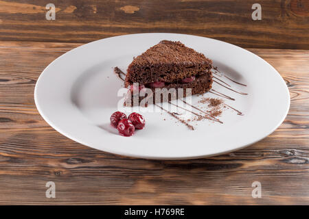 Schokoladenkuchen auf Platte auf dem hölzernen Hintergrund. Stockfoto
