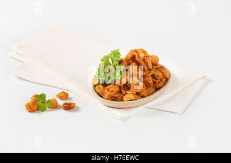 Teller mit salzig Schweinefleisch Grieben auf weiße Serviette Stockfoto
