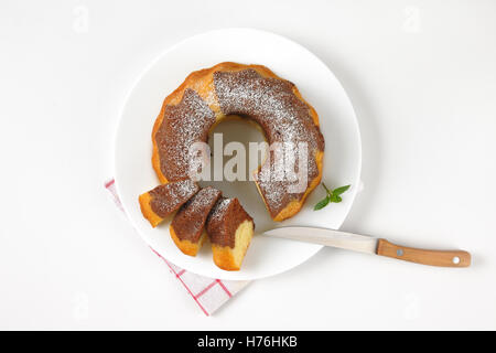 in Scheiben geschnitten Marmor Gugelhupf auf weißen Teller und kariertes Geschirrtuch Stockfoto