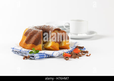 in Scheiben geschnitten Marmor Gugelhupf auf kariertes Geschirrtuch und Tasse Kaffee Stockfoto