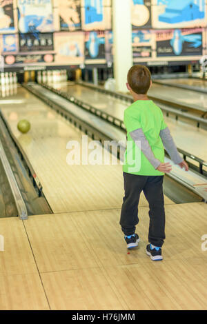 Fügen Sie ein 8 Jahre alter Junge, genießen Sie eine Partie Bowling in einer Retro-Stil-Bowlingbahn in der Nähe von Tel Aviv, Israel mit Old-Time bowling Stockfoto