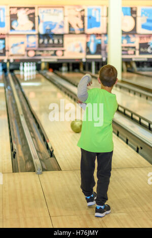 Fügen Sie ein 8 Jahre alter Junge, genießen Sie eine Partie Bowling in einer Retro-Stil-Bowlingbahn in der Nähe von Tel Aviv, Israel mit Old-Time bowling Stockfoto