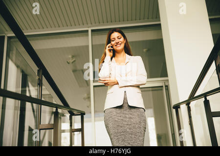 Business-Frau kommt die Treppe hinunter und reden über Handy Stockfoto