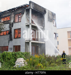 Feuerwehrmann bekämpfen ein Feuer mit einem Wasserschlauch Stockfoto