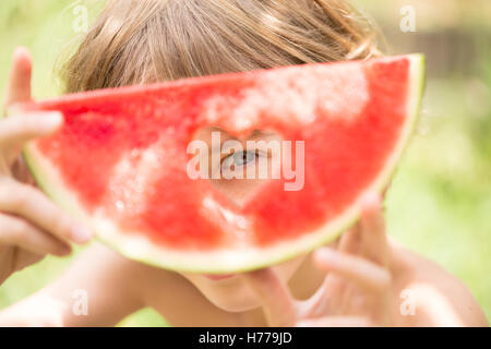 Jungen suchen durch Herz Form Loch in eine Wassermelone Stockfoto