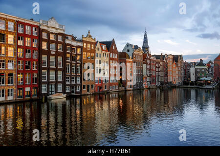 Tanz der Häuser auf dem Damrak und Oudekerksplein Tower, Amsterdam, Niederlande Stockfoto