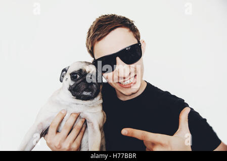 Porträt von ein lächelnder Mann mit seinem Mops Hund Stockfoto