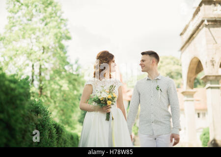 Frisch verheiratetes Paar laufen und springen im Park beim Händchenhalten Stockfoto