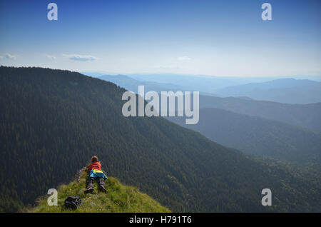 Weibliche Fotografen auf einem Berggipfel, schießen die Landschaft Stockfoto