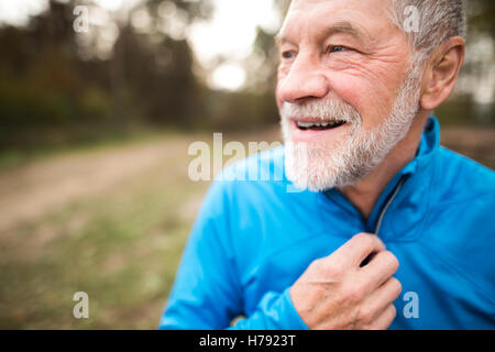 Senior-Läufer in der Natur. Man ruht, lächelnd. Hautnah. Stockfoto