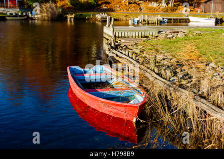 Kleine rote Ruderboot in Küstenlandschaft im Herbst. Bokevik außerhalb Ronneby in Schweden. Stockfoto