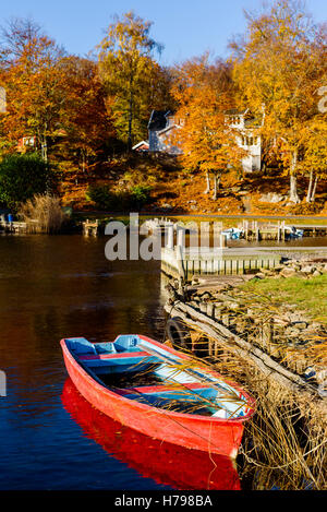 Kleine rote Ruderboot in Küstenlandschaft im Herbst. Bokevik außerhalb Ronneby in Schweden. Stockfoto