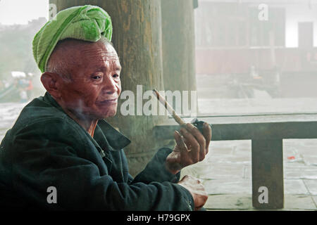 Ein Alter Mann raucht eine Pfeife im Tang'an Dorf in Zhaoxing, in der Provinz Guizhou, China Stockfoto