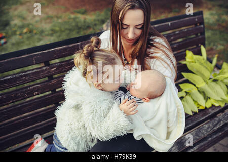 Mutter und zwei Töchtern Ausruhen auf einer Bank Stockfoto