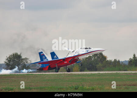 Kiew, Ukraine - 2. Oktober 2010: Sukhoi Su-30LL-Kampfflugzeugs in den Farben der russischen Flagge ist mit Rauch auf der Piste landen Stockfoto