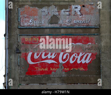 Alte Vintage-Werbeschilder auf der Seite des Mietshauses Koks Coca Cola Nachrichten der Welt und Bier Stockfoto