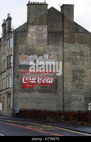 Alte Vintage-Werbeschilder auf der Seite des Mietshauses Koks Coca Cola Nachrichten der Welt und Bier Stockfoto