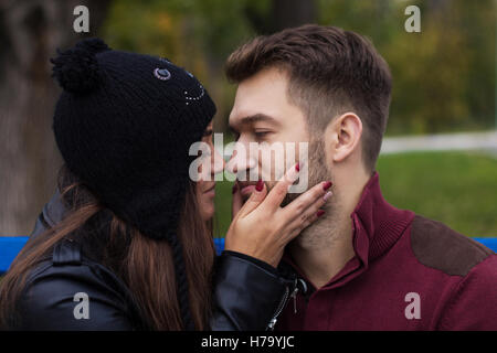 Closeup Aufnahme des jungen schönen stilvollen paar im Herbst Park. Sie ist ihn zu küssen. Er hat einen Bart. Sie hat ein piercing in die nos Stockfoto