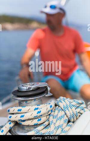 Details der Yacht und Seil auf dem Segelboot, der Mann in der Unschärfe im Hintergrund. Stockfoto