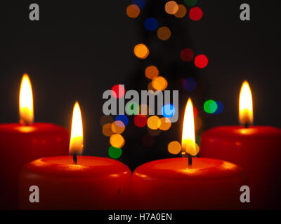 Vier brennende Advent Kerzen mit unscharfen Lichter Hintergrund eines Weihnachtsbaumes Stockfoto