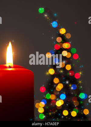 Weihnachtsbaum-Form mit zwei brennenden Kerzen und bunte Lichter Stockfoto