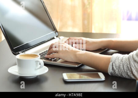 Gegenlicht Nahaufnahme von einer Dame Hände in einem Laptop sitzt in einem Schreibtisch zu Hause oder im Büro mit einem Fenster eingeben Stockfoto