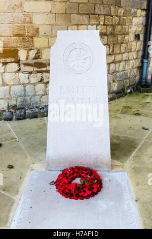 Grab und Gedenkstätte im Morgengrauen Märtyrer Krankenschwester Edith Cavell mit Mohn Kranz, der Kathedrale von Norwich, Norwich, Norfolk, East Anglia, Eastern England gedreht Stockfoto