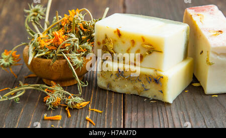 Calendula Trockenblumen mit handgemachten Seifen auf hölzernen Hintergrund Stockfoto