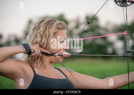 Blonde Frau mit einem Tanktop mit dem Ziel, Pfeil und Bogen Stockfoto