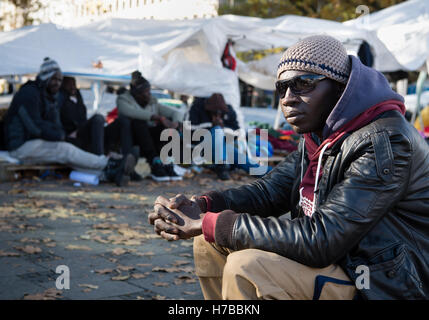 München, Deutschland. 4. November 2016. Moussa Mbawo, ein Flüchtling aus dem Senegal, sitzt in der Nähe der Flüchtlingslager am Sendlinger Tor in München, Deutschland, 4. November 2016. Moussa Mbawo kam vor vier Jahren in Deutschland und hat seit einigen Wochen an der Protest-Camp teilgenommen. Rund 80 Flüchtlingen im Lager, vor allem aus afrikanischen Staaten wollen jetzt auch trinken nach fünf Yeatrs Hungerstreik. Sie fordern ein Recht auf Aufenthalt und ein Ende zu Deportation im vermeintlich sicheren Ländern Ursprungs. Foto: MATTHIAS BALK/Dpa/Alamy Live-Nachrichten Stockfoto