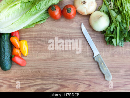 Frisches Gemüse (Tomaten, Paprika, Zwiebel, Gurke, Salat und Sellerie) mit Messer auf Holz schneiden Wildschwein Stockfoto