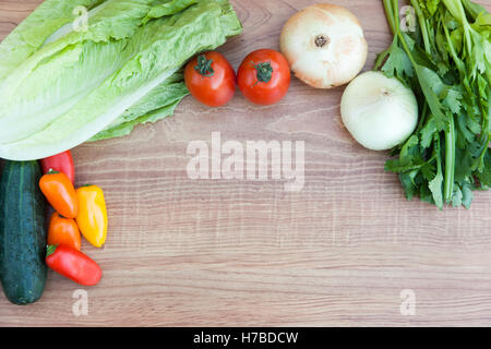 Frisches Gemüse (Tomaten, Paprika, Zwiebel, Gurke, Salat und Sellerie) mit Messer auf Holz schneiden Wildschwein Stockfoto