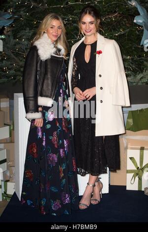 Helen David von Harrods und Lily James dreht sich auf den Weihnachtsbaum Lichter bei Harrods in London. Stockfoto