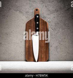 Küchenmesser und Schneidebrett am Steintisch. Kulinarische Themenabende Stillleben. Konzept des Kochens und der Zubereitung von Speisen. Stockfoto