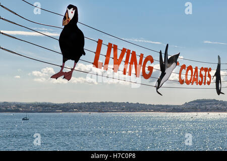 Bunte ausgesetzt Zeichen für 'Living Coasts" in Torquay, Devon, UK gegen einen sonnigen blauen Himmel im Sommer. Stockfoto