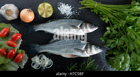 Wolfsbarsch auf einem schwarzen Hintergrund bereit, Kochen Stockfoto