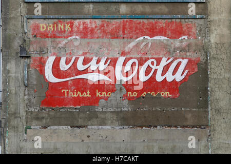 Alte Vintage-Werbeschilder auf der Seite des Mietshauses Koks Coca Cola Nachrichten der Welt und Bier Stockfoto