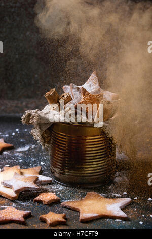 Hausgemachte Sternform Zucker Spritzgebäck mit Zucker und Zimt bestreuen Pulver in alten Blechdose Sackleinen Lappen mit cinnamo Stockfoto