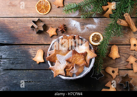 Hausgemachte Weihnachten Shortbread Sternform sugar Cookies unterschiedlicher Größe mit Zucker Pulver, Zimt, grüne Tanne Baum und Cookie Schnitt Stockfoto