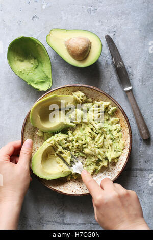 Maischen Avocado für Guacamole in eine Schüssel geben. Ansicht von oben Stockfoto