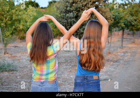 Beste Freunde für immer - zwei 12-jährige Mädchen Hand in Hand in eine Unendlichkeit ewig Zeichen zu bedeuten BFF Stockfoto