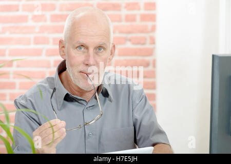 mittleren Alters Geschäftsmann arbeiten am Computer im Büro Stockfoto