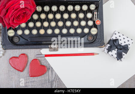 alte Schreibmaschine mit einer roten rose Stockfoto