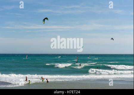 Kite und Windsurfer in brechenden Wellen am spanischen Strand Stockfoto