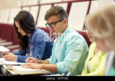 Gruppe von Studenten mit Bücher schreiben am Vortrag Stockfoto